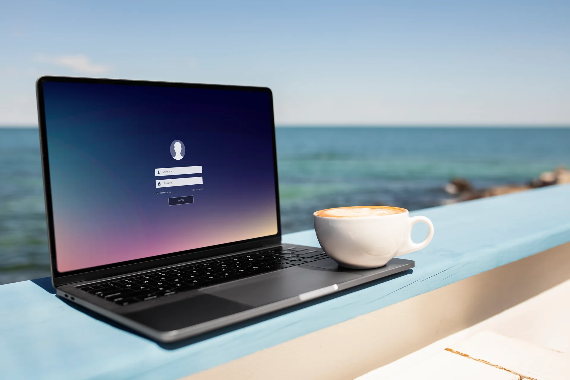 A laptop and coffee overlooking the sea